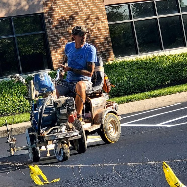 Striping machine applying fresh parking lines on a lot